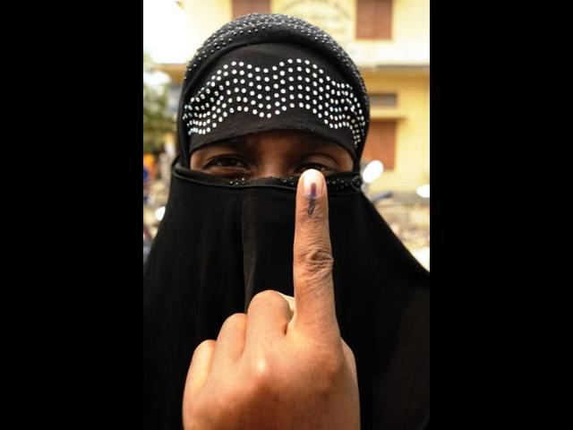 A voter shows her ink-marked finger after after casting her ballot at a polling booth at Pachmile village, in Assam. (AFP photo)
