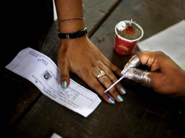 An election officer applies an indelible ink mark on the finger of a woman during the first phase of elections in Dibrugarh, Assam. (AP Photo)