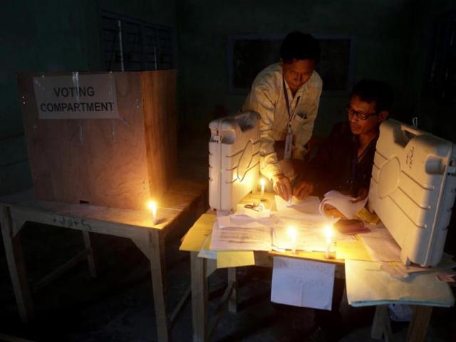 Polling officials check voting materials by candlelight next to electronic voting machines at a voting center on the eve of the second phase of parliamentary elections at Senapati, Manipur. (AP Photo)
