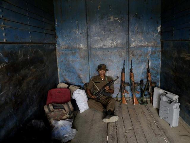 A security man sits near electronic voting machines inside a truck headed to a polling center on the eve of the second phase of parliamentary elections at Senapati, Manipur. (AP Photo)