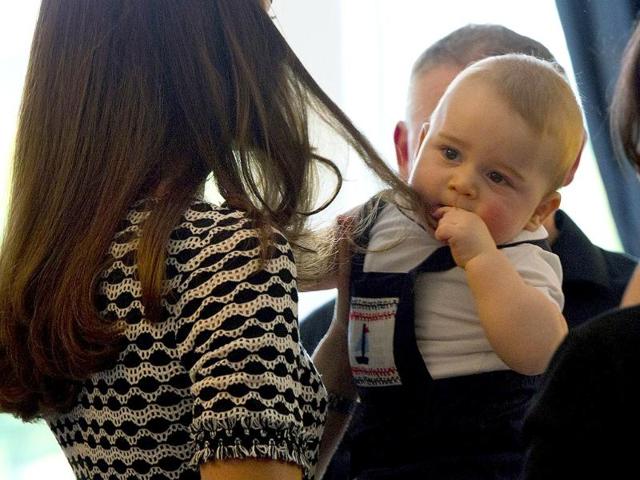 Prince George plays with his mother, Catherine's hair, during a Plunket nurse and parents group visit in Wellington. (AFP photo)