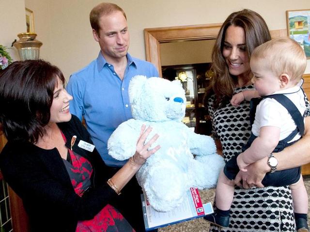 Prince George gets a large soft bear as a gift from Plunket's area manager, Tina Syme (L) during his visit to the Plunket nurse and parents group in Wellington. (AFP photo)