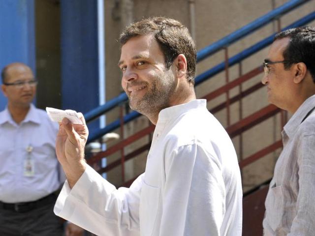 Congress leader Rahul Gandhi shows his Voter ID card as he enters a polilng booth to vote in New Delhi. (Sonu Mehta/HT Photo)