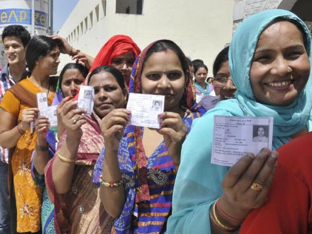 Female voters line up to cast their votes at a polling booth in Vinod Nagar of East Delhi. (Sonu Mehta/HT Photo)