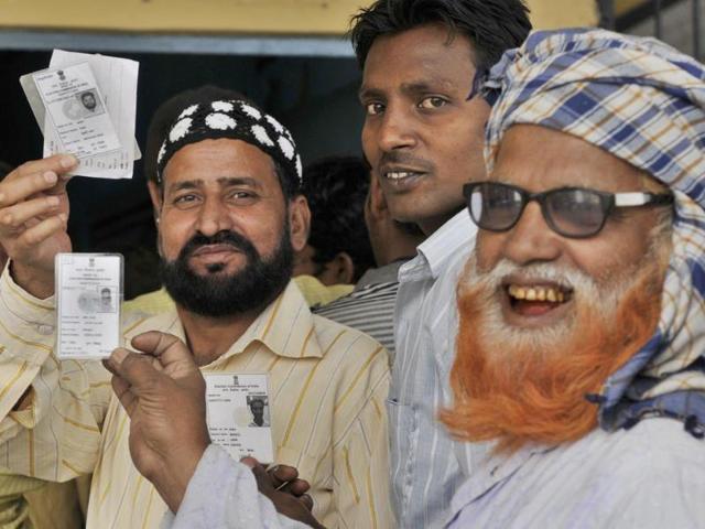Muslim voters show their election ID cards before casting their vote at the Kathputli colony polling booth during the Lok Sabha election in New Delhi. (Mohd Zakir/HT Photo)
