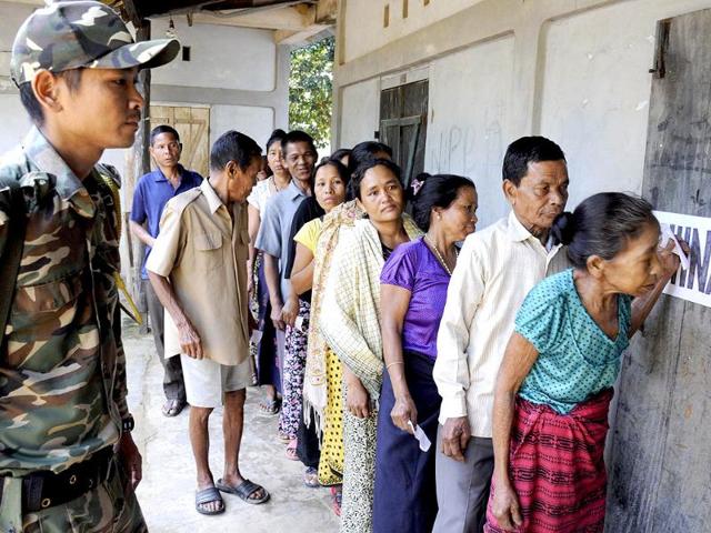 Security personnel look on as a voter leaves a polling station after casting her ballot in Kahnmun in Mizoram. (AFP photo)