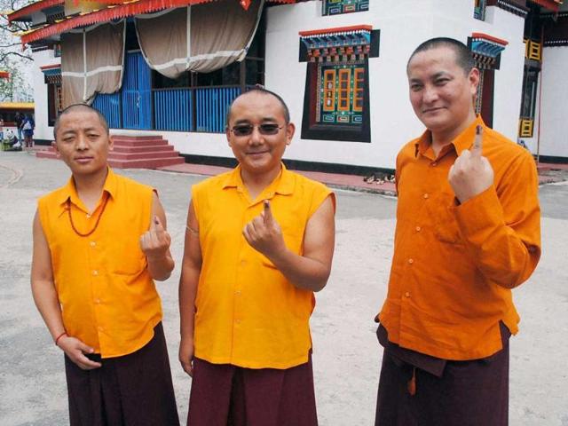 Monks showing their ink marked fingers after casting votes for Lok sabha polls at Enchey Monastery in Gangtok. (PTI photo)