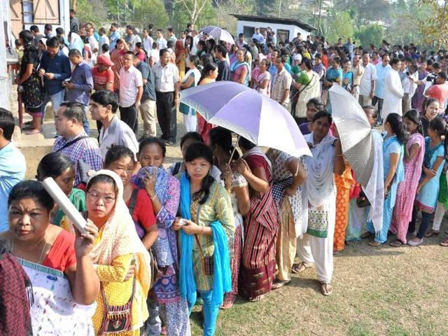 People wait in queues to cast their votes for Lok Sabha polls at a polling station, at Diphu in Karbi Anglong district of Assam. (PTI photo)