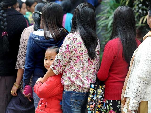 A child looks on as Sikkimese voters queue to cast their ballot at a polling station in Gangtok, in Sikkim. (AFP photo)