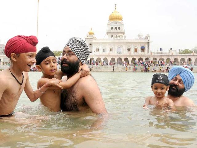 Sikh devotees take a holy dip at sarovar at Gurudwara Bangla Sahib on the occasion of Baisakhi festival in New Delhi. (Sonu Mehta/HT Photo)