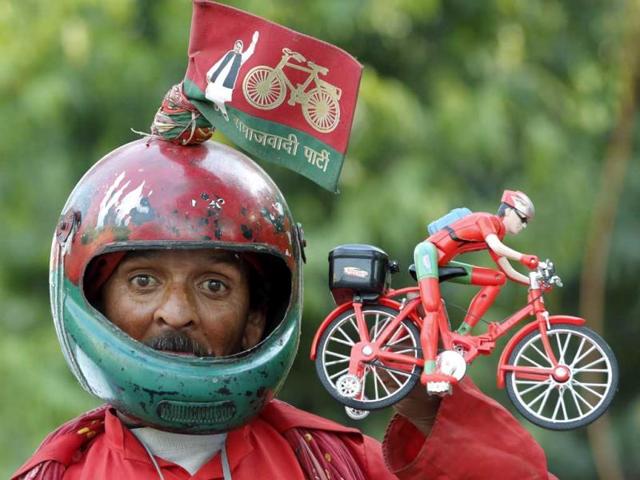 Salamat Ali, a supporter of Samajvadi Party (SP) holds a toy bicycle, the party symbol, as he campaigns for the party in Lucknow, in the northern Indian state of Uttar Pradesh. (Rajesh Kumar Singh/AP Photo)