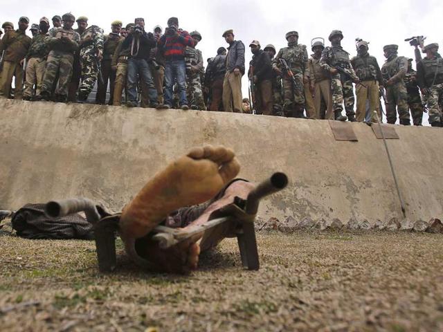 Indian security personnel and others look at the body of one of the two suspected militants, placed inside a police station in Khrew some 19 miles south of Srinagar. (AP Photo)
