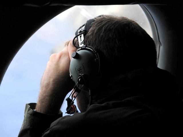 A crew member aboard a Royal New Zealand Air Force (RNZAF) P-3K2 Orion aircraft looks out an observation window as they fly over the southern Indian Ocean to continue the search for missing Malaysian Airlines flight MH370. (Reuters)