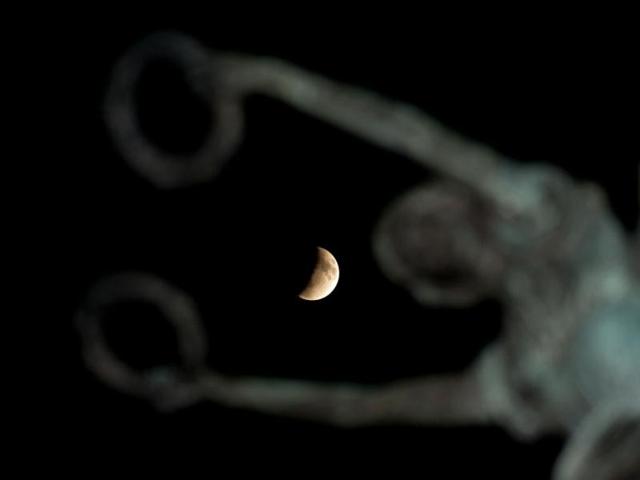 The moon is pictured over the El Salvador del Mundo Monument in San Salvador, El Salvador. (AFP Photo)