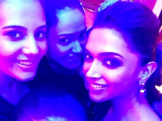 Deepika Padukone poses with fans for a selfie.