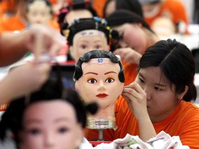 Hairdressers use mannequins to pin-curl during a competition at the K-Beauty World Fashion Festival in Gwacheon, South Korea. About 15,000 makeup artists, hairdressers, fashion designers and aestheticians from 56 countries participated in the annual event to promote the Korean culture. (AP)