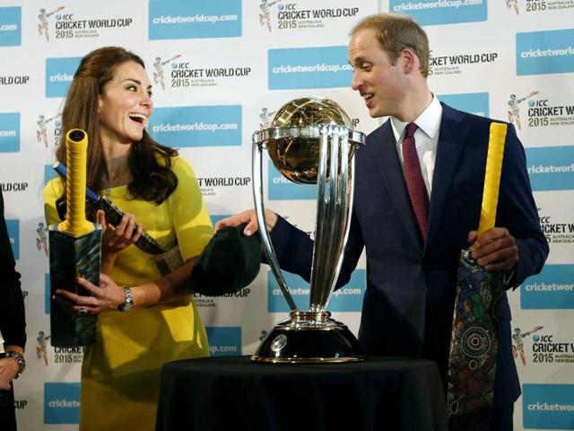 Britain's Prince William and his wife Kate, the Duchess of Cambridge, hold cricket bats presented to them in front of the World Cup during a reception at the Sydney Opera House. (AP photo)