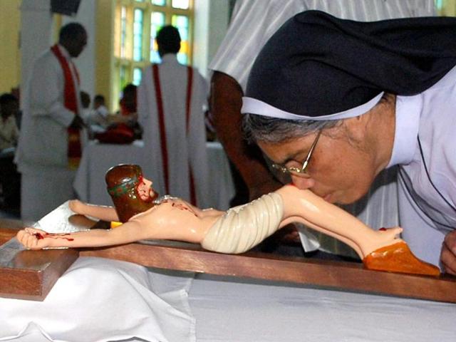 A nun kisses the feet of Jesus Christ on the occasion of Good Friday at a Catholic Church in Dibrugarh. (PTI photo)