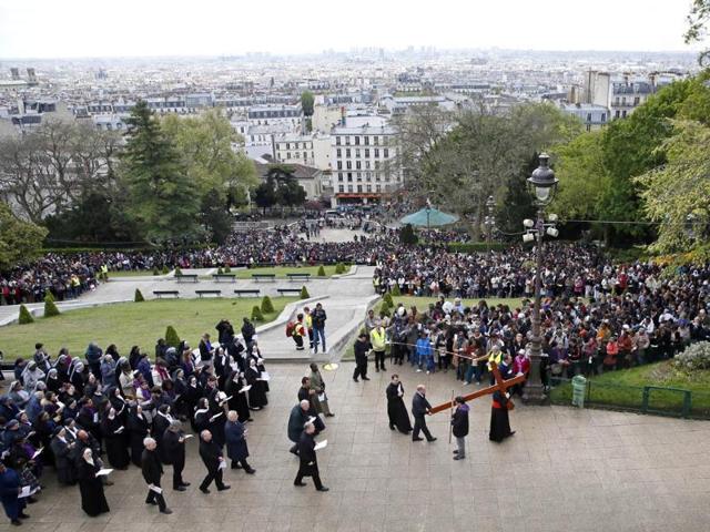 France's Cardinal Andre Vingt-Trois carries a wooden cross as he attends a Good Friday procession in front of the Sacre-Coeur basilica on the Montmartre hill of Paris. (AFP photo)