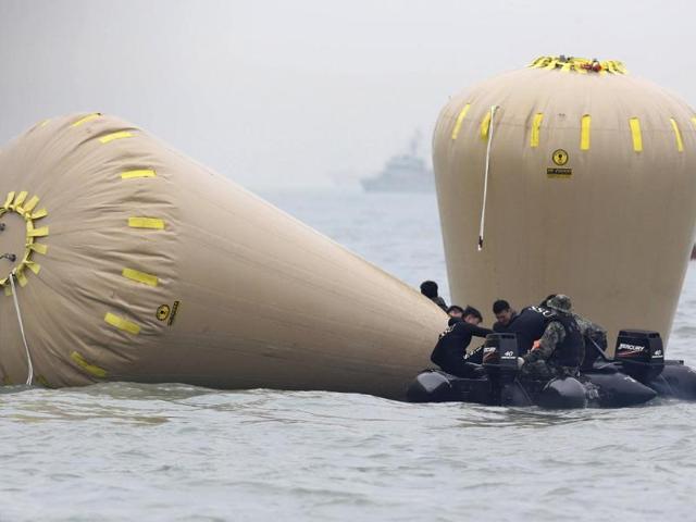 Rescue workers install floats where the capsized passenger ship "Sewol" sank in the sea off Jindo. (Reuters photo)