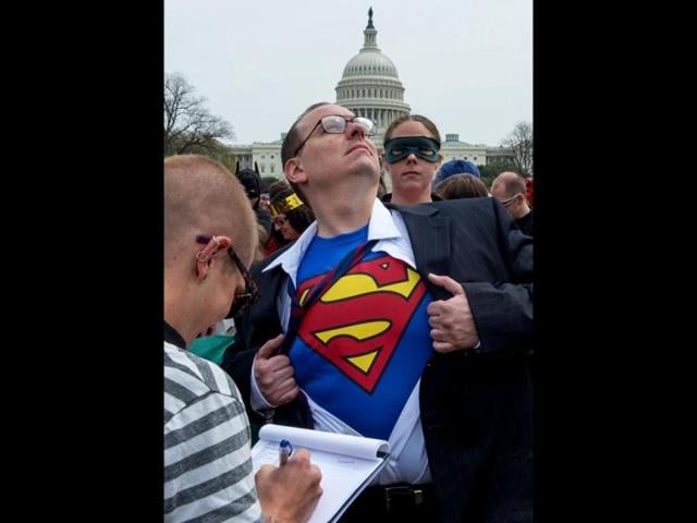 A man identifies his hidden super-hero identity at the Awesome Con 2014 in Washington, DC during an attempt to break a Guinness world records record of people as comic book charactors. (AFP photo)