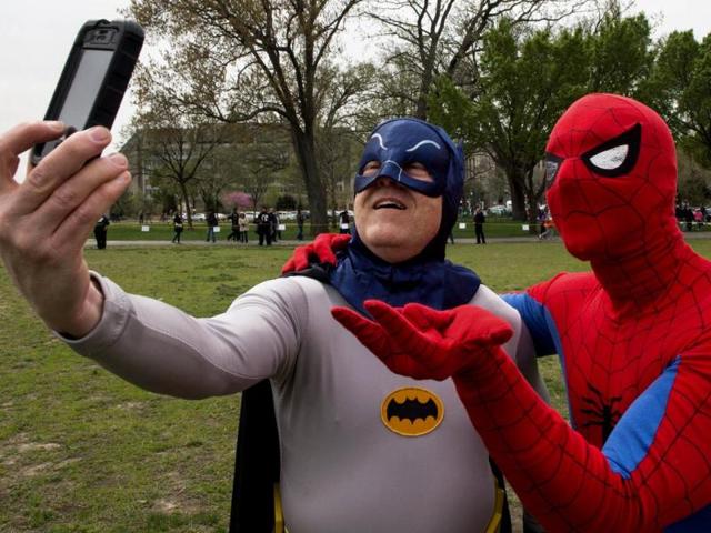 Two men in super-hero uniforms take a selfie while waiting at Awesome Con 2014 in Washington during an attempt to break a Guinness world records record of people as comic book charactors. (AFP photo)