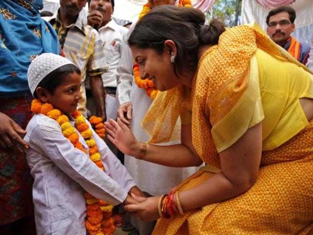 Bharatiya Janata Party (BJP) candidate Smriti Irani (R) talks to a young Muslim boy at an election rally in Amethi. (AP Photo)
