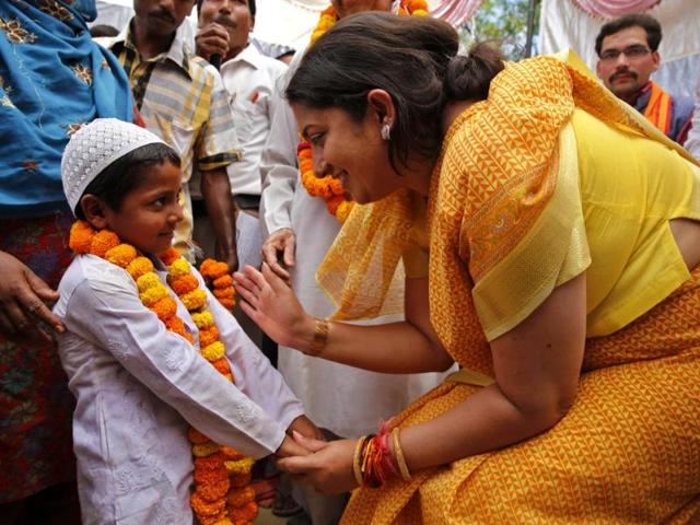 BJP candidate Smriti Irani, talks to a young Muslim boy at an election rally in Amethi (AP Photo)