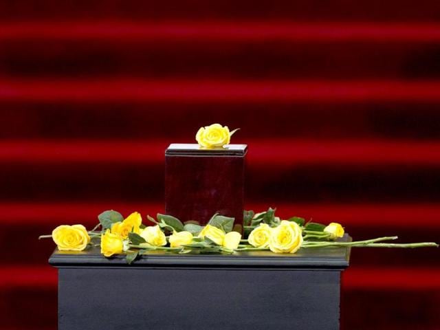 Yellow roses brought by guests surround the urn containing Nobel Literature laureate Gabriel Garcia Marquez's ashes during an homage to the author at the Palace of Fine Arts in Mexico City. (AP Photo)