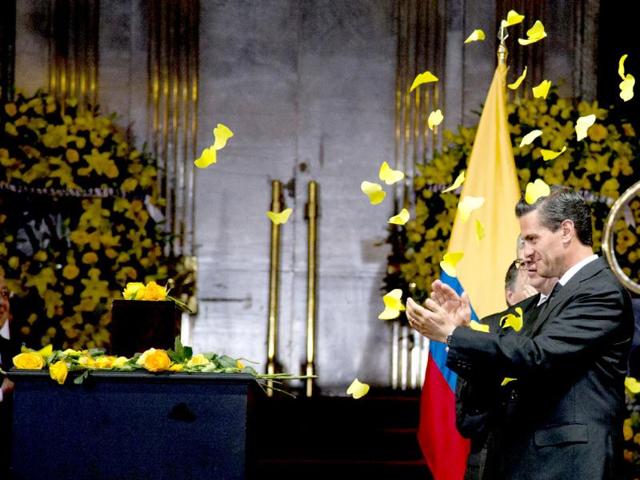 Yellow paper butterflies fall as Mexico's President Enrique Pena Nieto stands next to the urn containing the ashes of Colombian Nobel Literature laureate Gabriel Garcia Marquez. (AP Photo)