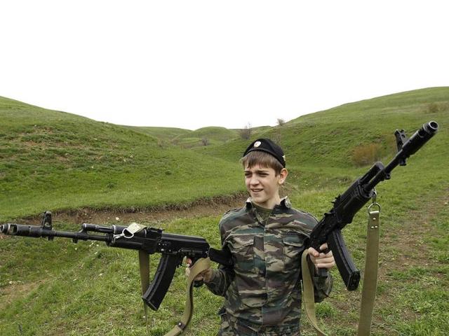 A student from the General Yermolov Cadet School holds two rifles during a two-day field exercise near the village of Sengileyevskoye, just outside the south Russian city of Stavropol. (Reuters)