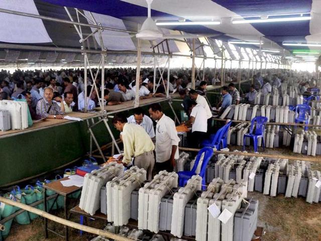 Poll officials waiting in queues to collect EVMs from a distribution centre at Saruhozai on the eve of Lok Sabha elections in Guwahati. (PTI photo)