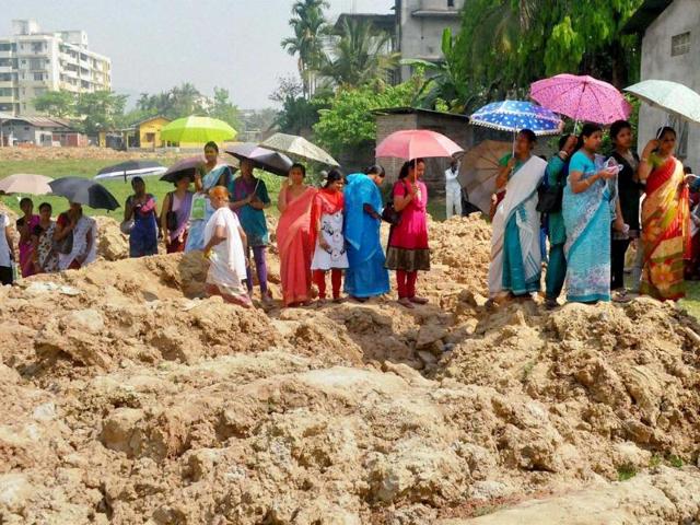 People standing in queue to cast their vote at Baghorbori area of Guwahati on Thursday. (PTI Photo)