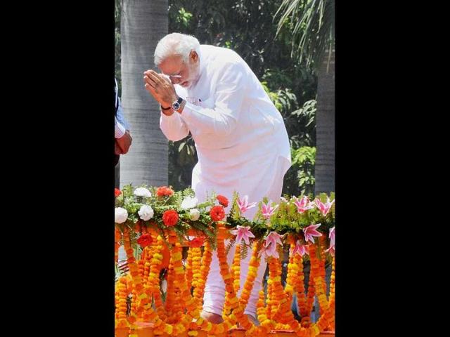 BJP PM candidate Narendra Modi greets supporters at a road show before filing his nomination papers in Varanasi. (PTI photo)
