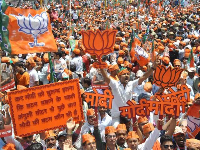 BJP PM candidate Narendra Modi waves to supporters as he arrives in an open vehicle to file his nomination in Varanasi. (AP photo)