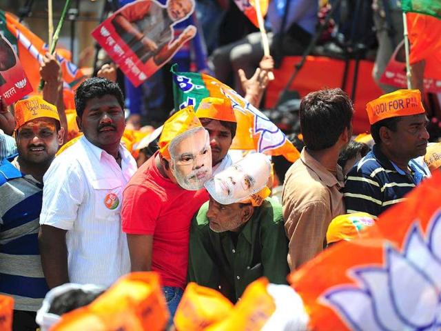 Supporters of BJP prime ministerial candidate Narendra Modi wait for his arrival to file his nomination papers in Varanasi. (AFP photo)