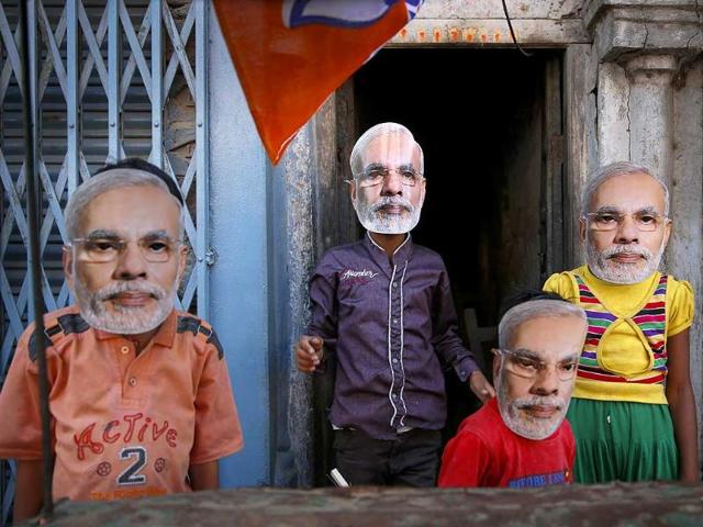 Children play wearing masks of BJP prime ministerial candidate Narendra Modi as he moves on a vehicle to file his nomination papers in Varanasi. (AP photo)