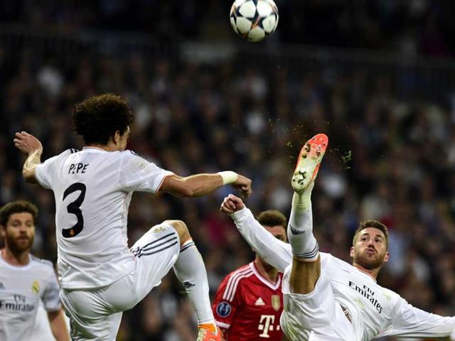Real Madrid's defender Sergio Ramos (R) jumps to kick the ball past Pepe during the UEFA Champions League semifinal first leg match Real Madrid CF vs FC Bayern Munchen in Madrid. (AFP photo)