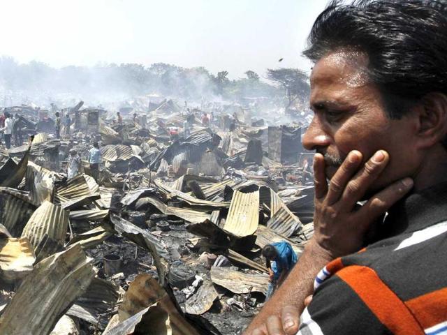 A man looks at his burnt house after the fire in JJ cluster at Vasant Kunj, in New Delhi. (HT photo/Sanjeev Verma)