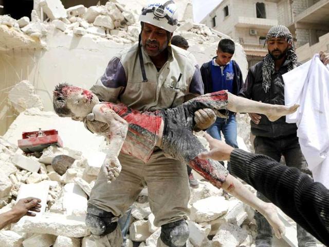 A rescuer carries a dead boy after what activists said was a barrel bomb dropped by forces loyal to Syria's President Bashar al-Assad in Aleppo's Karam al-Beik neighborhood. (Reuters photo)