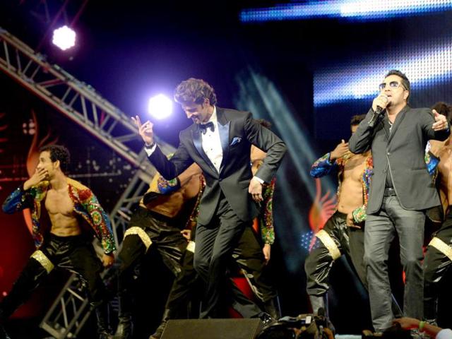Hrithik Roshan dances with Mika Singh on stage during the IIFA Magic of the Movies show at IIFA Awards. (AFP)