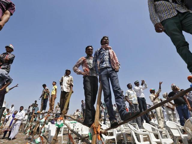 Congress' supporters stand on poles to get a glimpse of Rahul Gandhi during an election campaign rally in Gujarat. (Reuters photo)