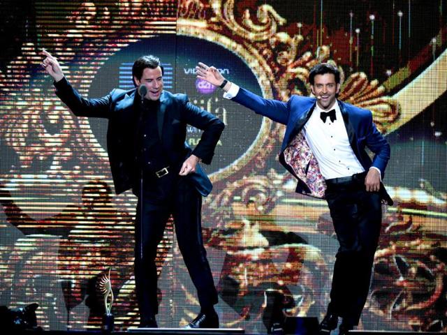 Hollywood actor John Travolta (L) shows Bollywood actor Hrithik Roshan a dance step on stage during the fourth and final day of the 15th International Indian Film Academy (IIFA) Awards at the Raymond James Stadium in Tampa, Florida. (AFP)