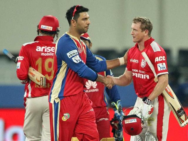 George Bailey of the Kings X1 Punjab and Yuvraj Singh of the Royal Challengers Bangalore shake after the match in Dubai on Monday. (PTI Photo)