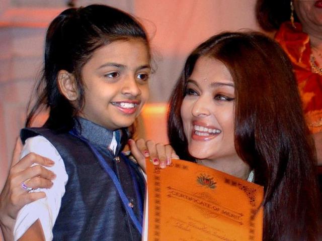 A kid smiles as she poses with Aishwarya Rai Bachchan during a musical concert in Mumbai. (PTI Photo)