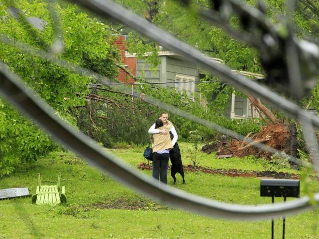 A homeowner gets hug of support from a neighbor after a tornado destroyed her home in Tupelo, Mississippi. (AP Photo)