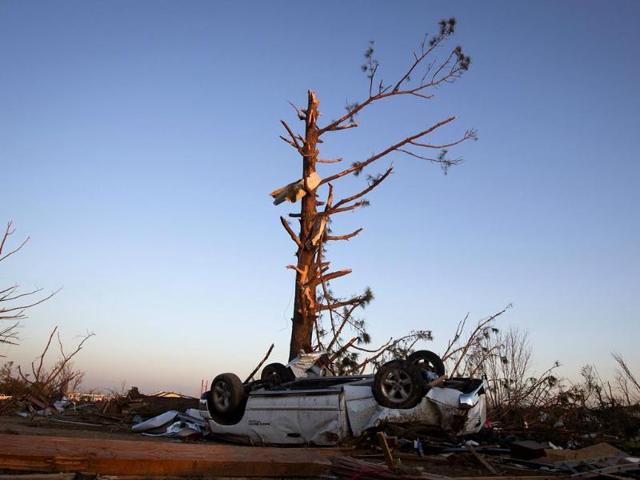 An upturned truck lies under a tree that has lost most of its branches, following a tornado near Vilonia, Arkansas, at sunset. (Reuters Photo)