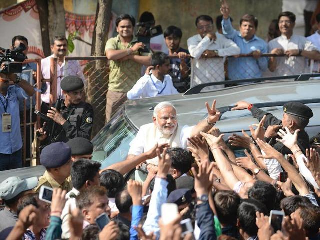 BJP's PM candidate Narendra Modi gestures towards supporters after casting his vote at a polling station in Ahmedabad. (AFP photo)