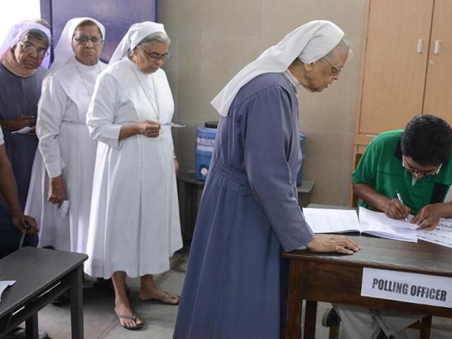 Catholic nuns check their names with election commision officials as they wait to cast their votes at a polling booth in Hyderabad. (AFP photo)
