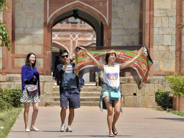 Foreign tourists from South Korea take precautions against the hot weather at Humanyun's Tomb in New Delhi, India. (Sushil Kumar/HT Photo)